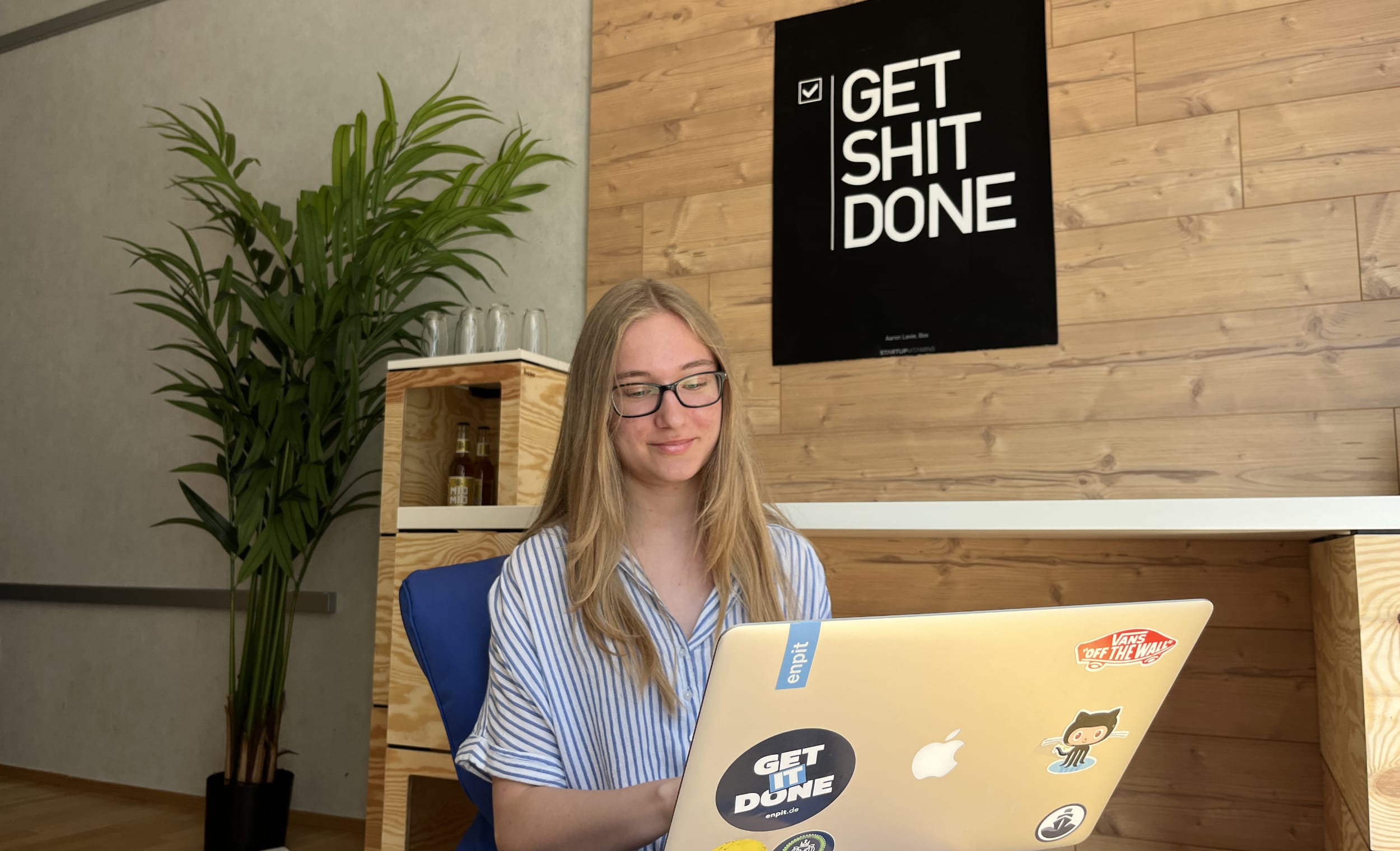 Emely sitzt in der enpit Idennwerkstatt und programmiert mit ihrem Laptop
